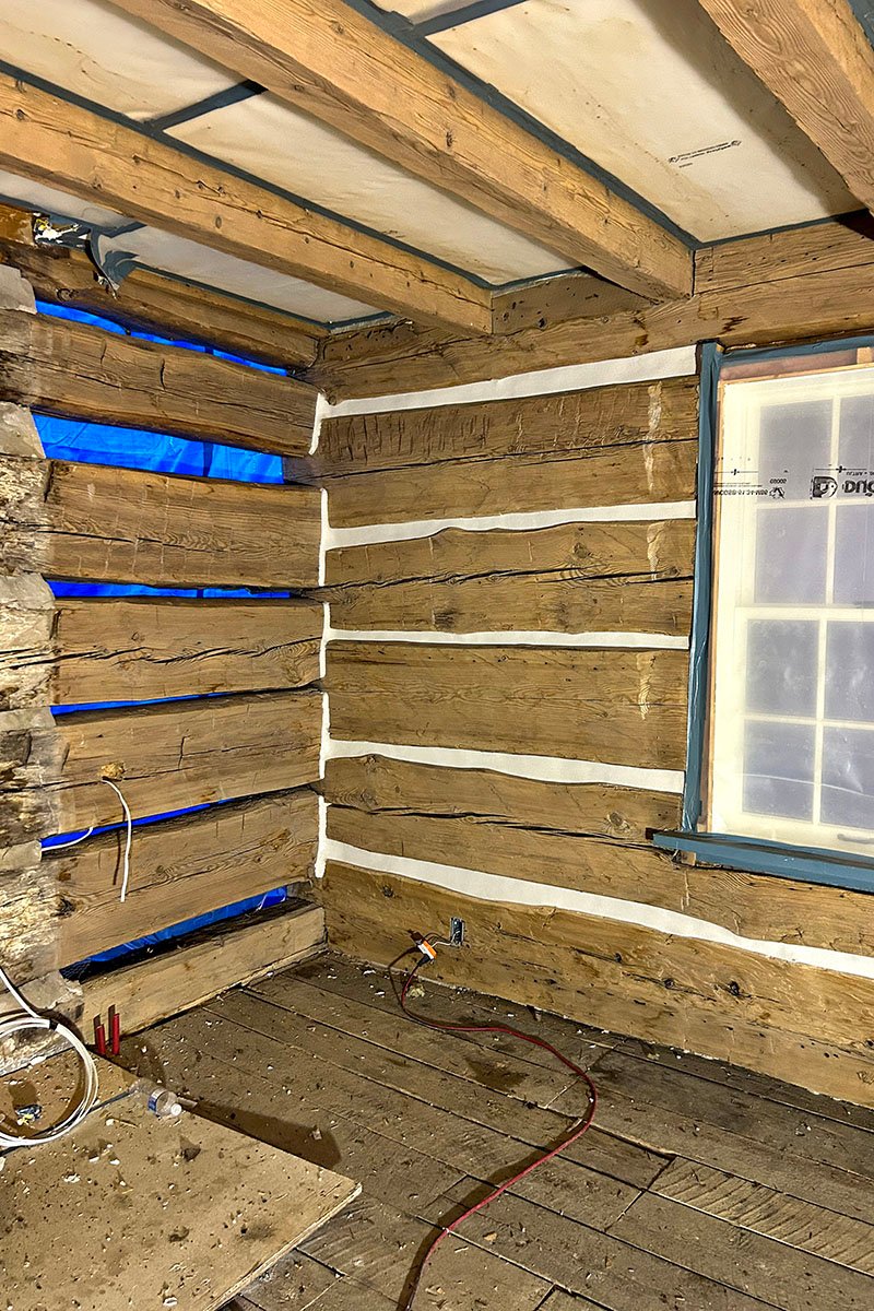 Rustic wooden cabin interior under renovation with exposed beams
