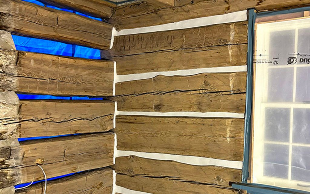 Restoration of rustic wooden cabin interior wall