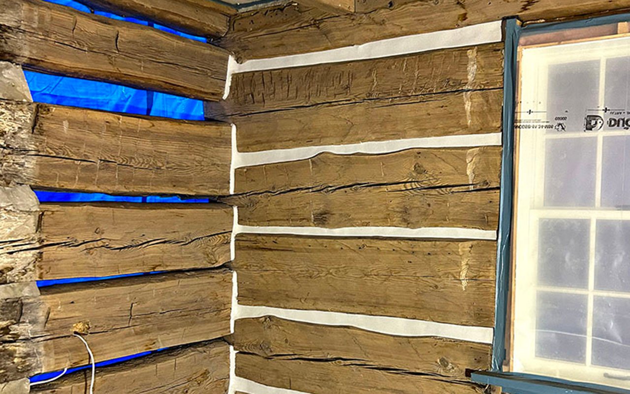 Restoration of rustic wooden cabin interior wall