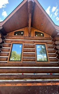 Beautiful log cabin with large windows under a clear sky