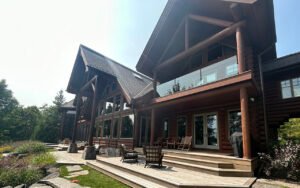 Modern log cabin exterior with large windows in forest setting