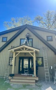 Workers painting the exterior of a modern wooden house