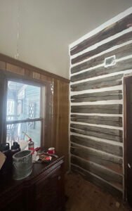 Interior renovation showcasing rustic wooden wall and modern finishing
