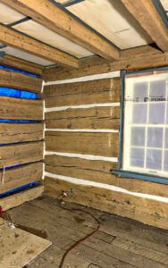 Renovated rustic log cabin interior with exposed wooden beams