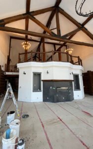 Lodge interior renovation with wooden beams and a modern fireplace