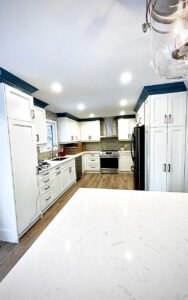 Modern kitchen interior with white cabinets and blue accents in recent renovation