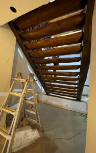 Rustic wooden staircase under construction in a modern space