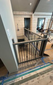 Modern staircase with black metal railing in a renovated home