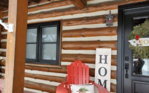 Cozy log cabin porch with red chair and holiday decor