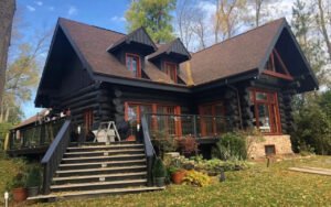 Rustic log cabin with autumn foliage in a forested setting