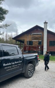 Log home restoration in progress with scaffolding and service truck
