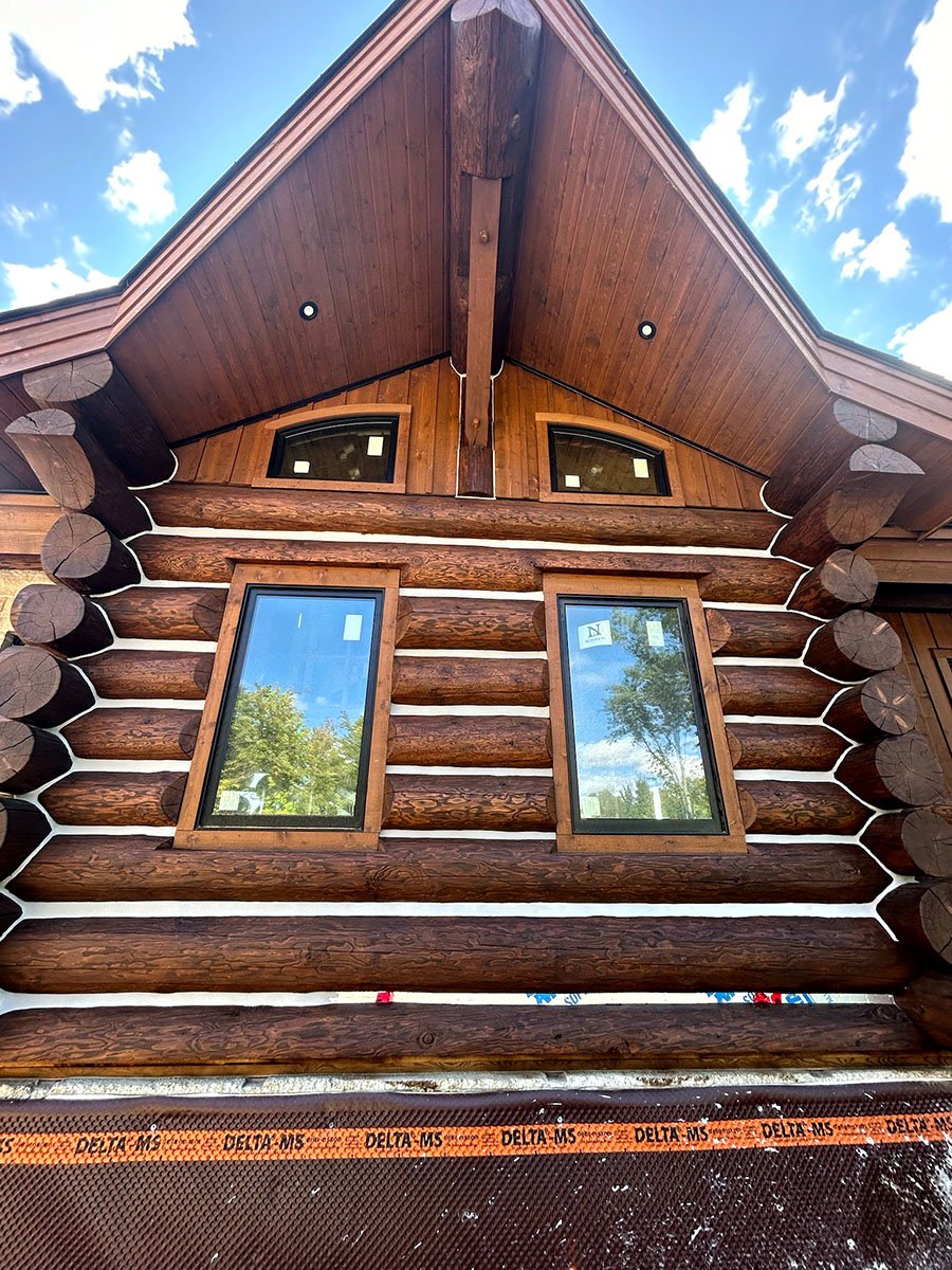 Rustic log cabin exterior with large windows