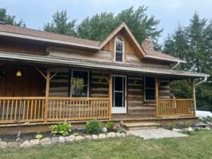 Rustic log cabin with wooden porch and garden