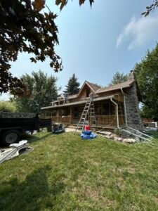 Stone cottage with roof renovation in progress under blue sky