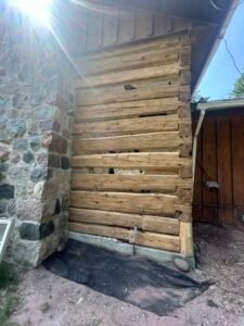 Restored log cabin wall with sunlight streaming through