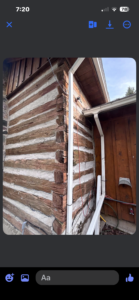 Rustic log cabin corner with visible roof and wiring