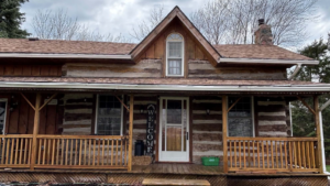 Rustic log cabin with front porch in rural setting